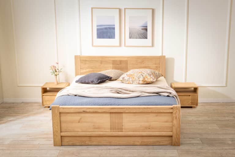 Dubová postel Luise z masivu přináší do ložnice nadčasovou eleganci a poctivé řemeslné zpracování. Jemné drážkování, oblé hrany a přirozená kresba dubu vytvářejí harmonický celek, který zahřeje na pohled i na dotek. Praktický úložný prostor pod zvedacím roštem i v přední části postele nabízí chytré řešení pro každodenní komfort.