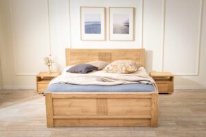 Dubová postel Luise z masivu přináší do ložnice nadčasovou eleganci a poctivé řemeslné zpracování. Jemné drážkování, oblé hrany a přirozená kresba dubu vytvářejí harmonický celek, který zahřeje na pohled i na dotek. Praktický úložný prostor pod zvedacím roštem i v přední části postele nabízí chytré řešení pro každodenní komfort.